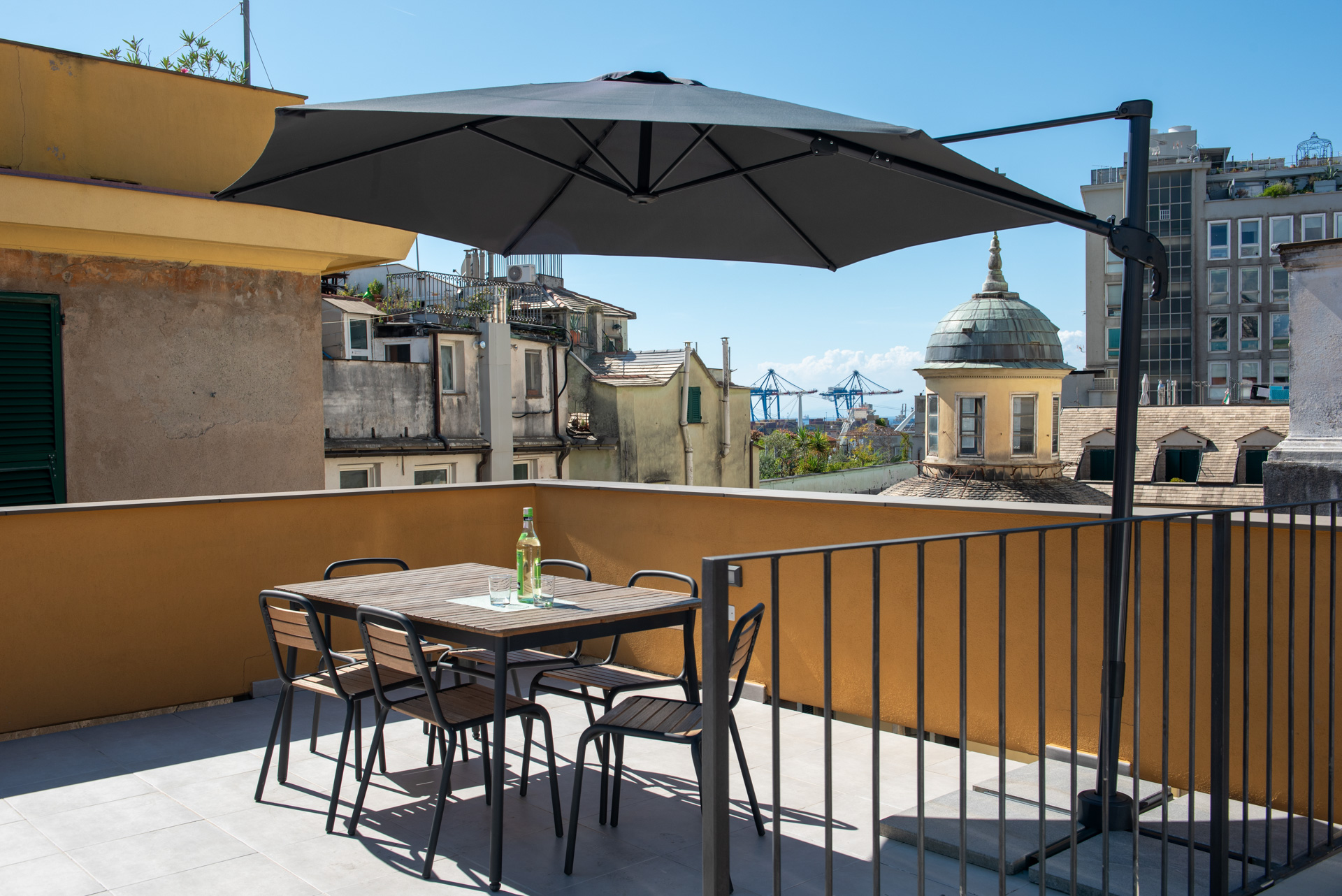 Grande terrazza privata allestita con tavolo da pranzo e sedie per momenti di relax nel centro di Genova Centro storico in Palazzo dei Rolli.