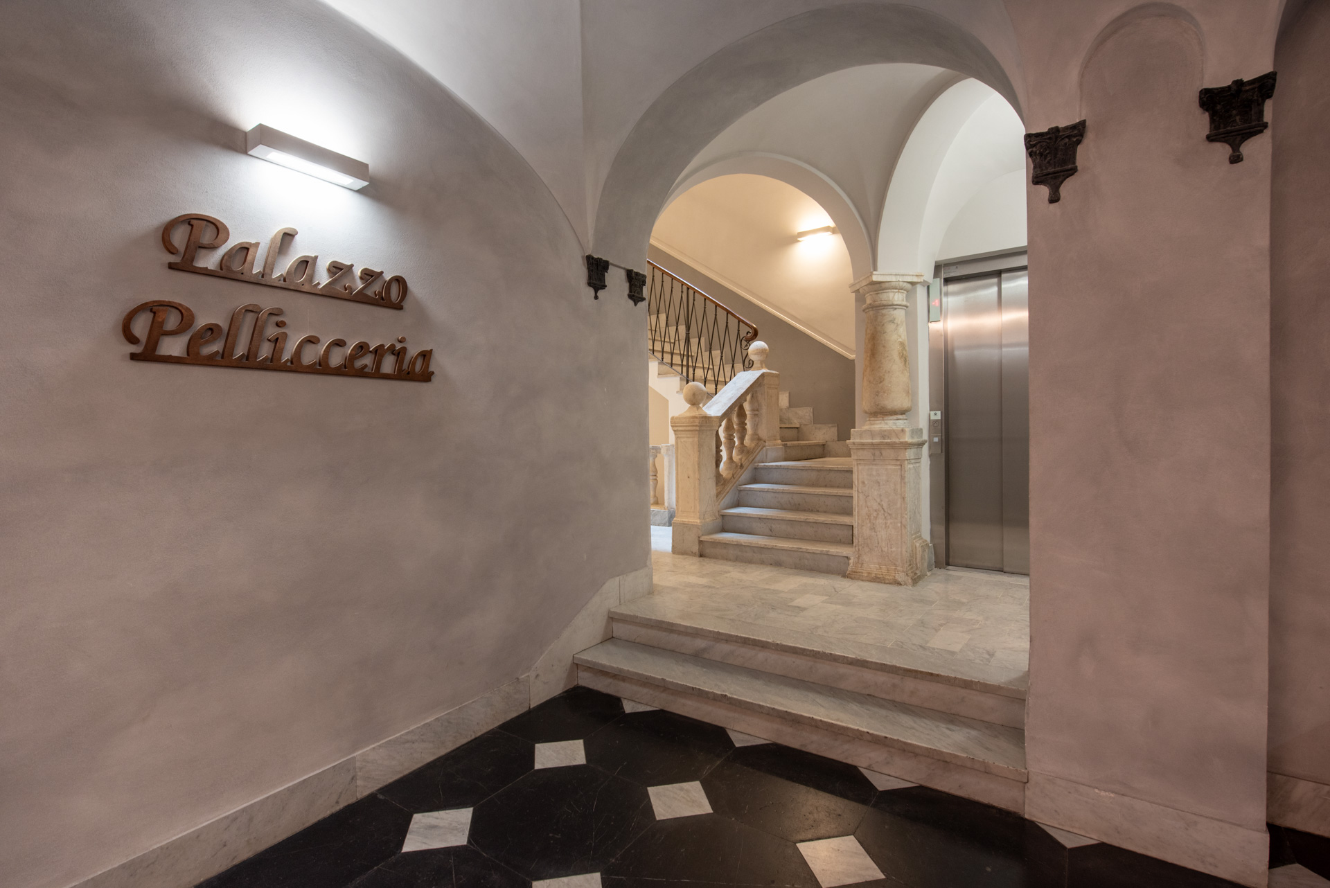 Maestoso portone d'ingresso in legno finemente lavorato dello storico Palazzo dei Rolli ristrutturato nel centro di Genova.